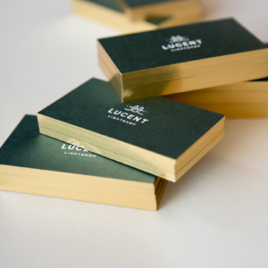 custom business cards with white foil on duplexed green and white paper with gold gilded edges