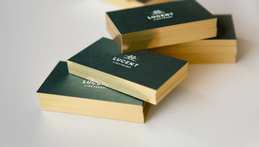 custom business cards with white foil on duplexed green and white paper with gold gilded edges