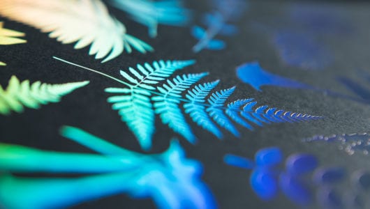 close up image of holographic deboss letterpress printed foil on black paper