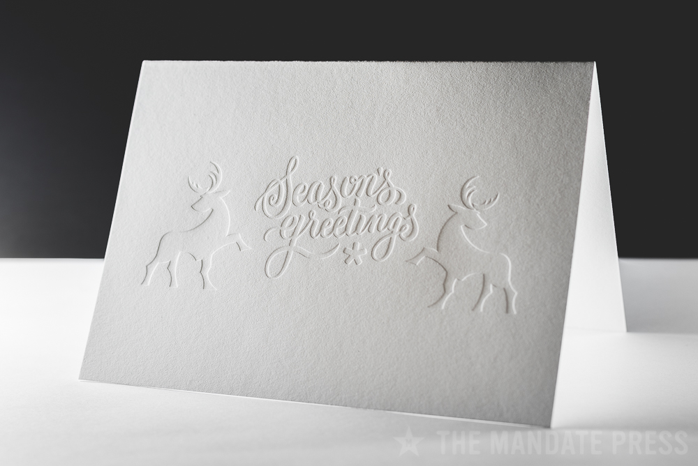 image of letterpress printed greeting card with blind seasons greetings deboss