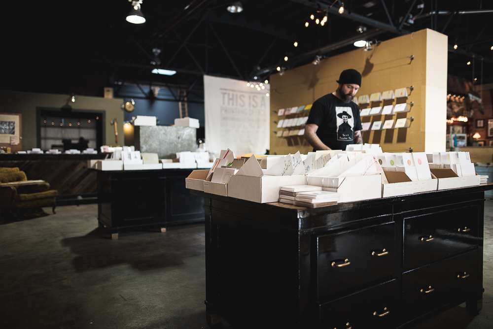 Ben Webster organizing letterpress greeting cards inside The Mandate Press