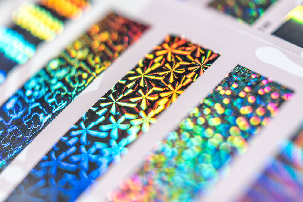 Close up picture showing samples of patterned holographic letterpress foil